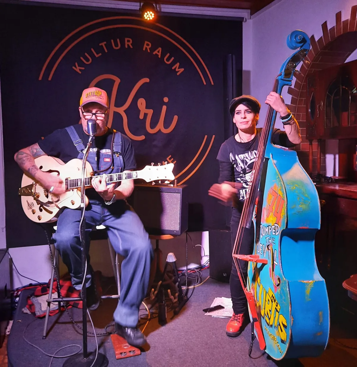 Chris Curtis mit Gretsch-Gitarre, daneben eine Kontrabassistin mit handbemaltem Kontrabass