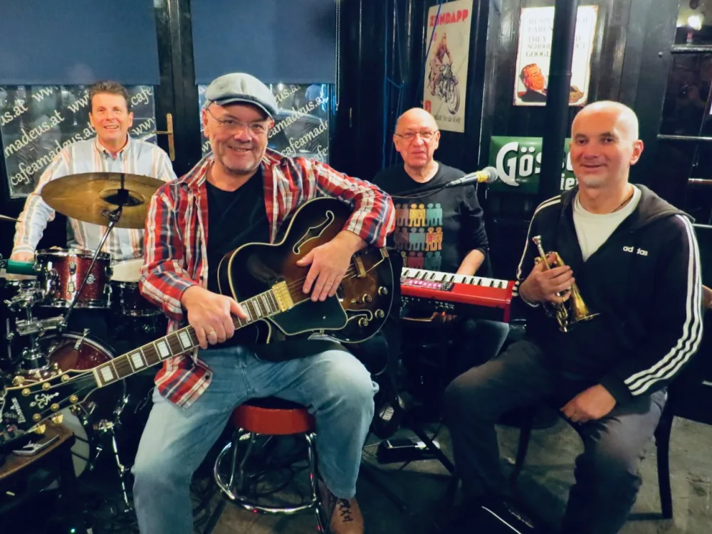 Die vier Musiker von Knacka4 mit Gitarre, Trompete, Keyboard und Schlagzeug in einem Lokal